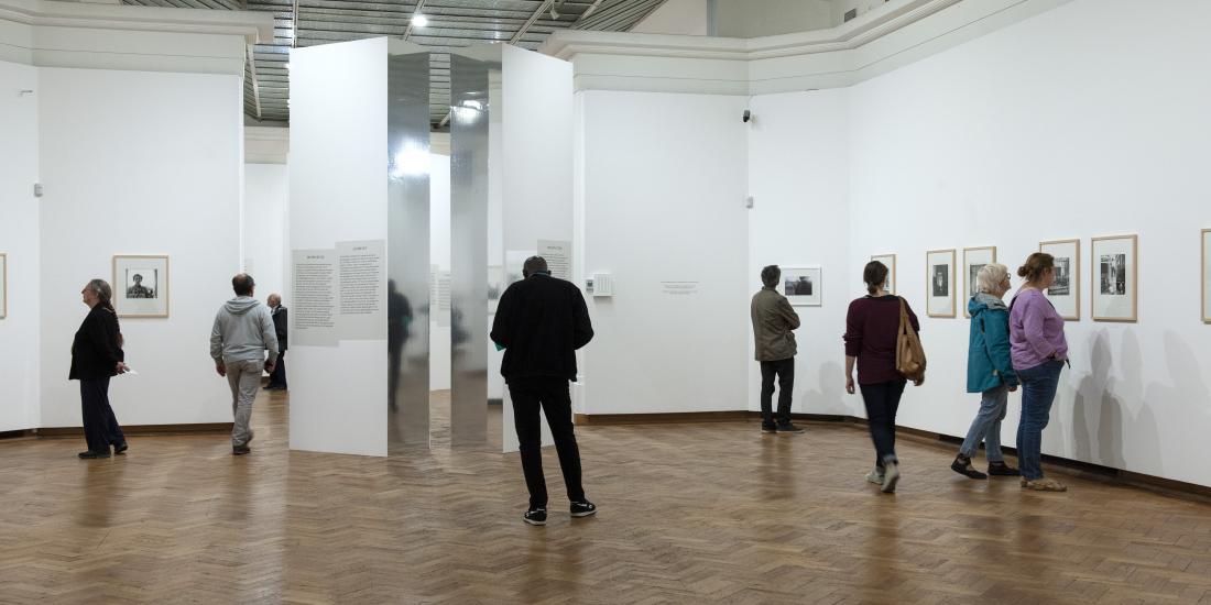 Bezoekers wandelen rond in de fototentoonstelling van Vivian Maier