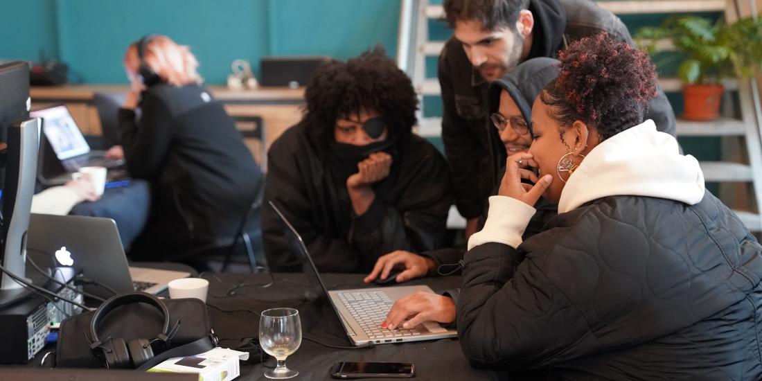 Workshop participants watching a game together on a laptop.