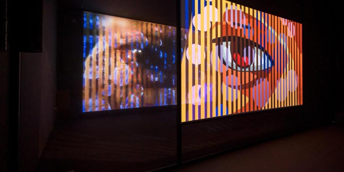 Ho Tzu Nyen, T for Time, 2023–ongoing, 2-channel synchronized HD videos (16:9, colour, and eight-channel sound, approximately 60 min), voile screen, scrim walls, real-time algorithmic editing and compositing system. Installation view at Singapore Art Museum, 2023.