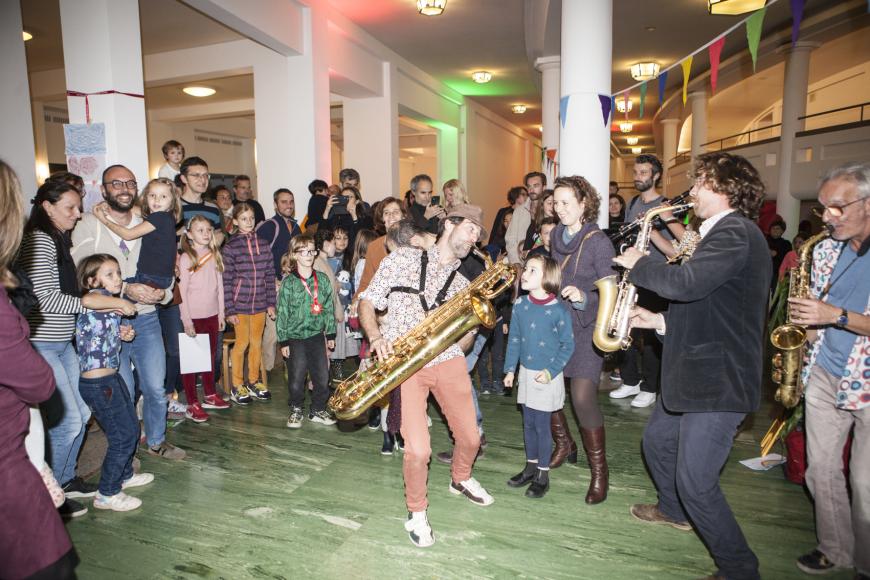 Children and parents gathered around some artists during performance.