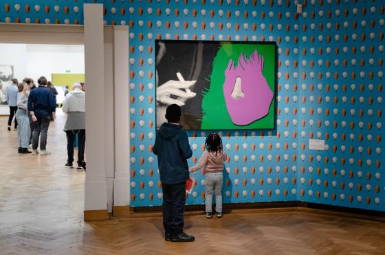The image shows children admiring a work by John Baldessari at Bozar